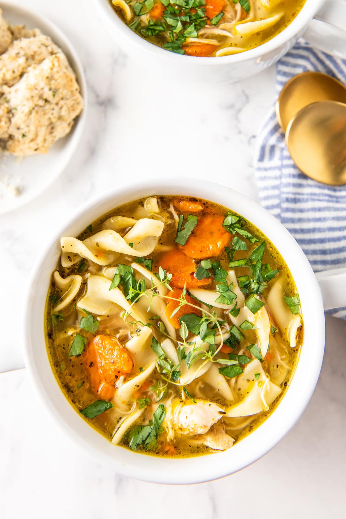 A bowl of easy chicken noodle soup with tender chicken and fresh herbs on top.