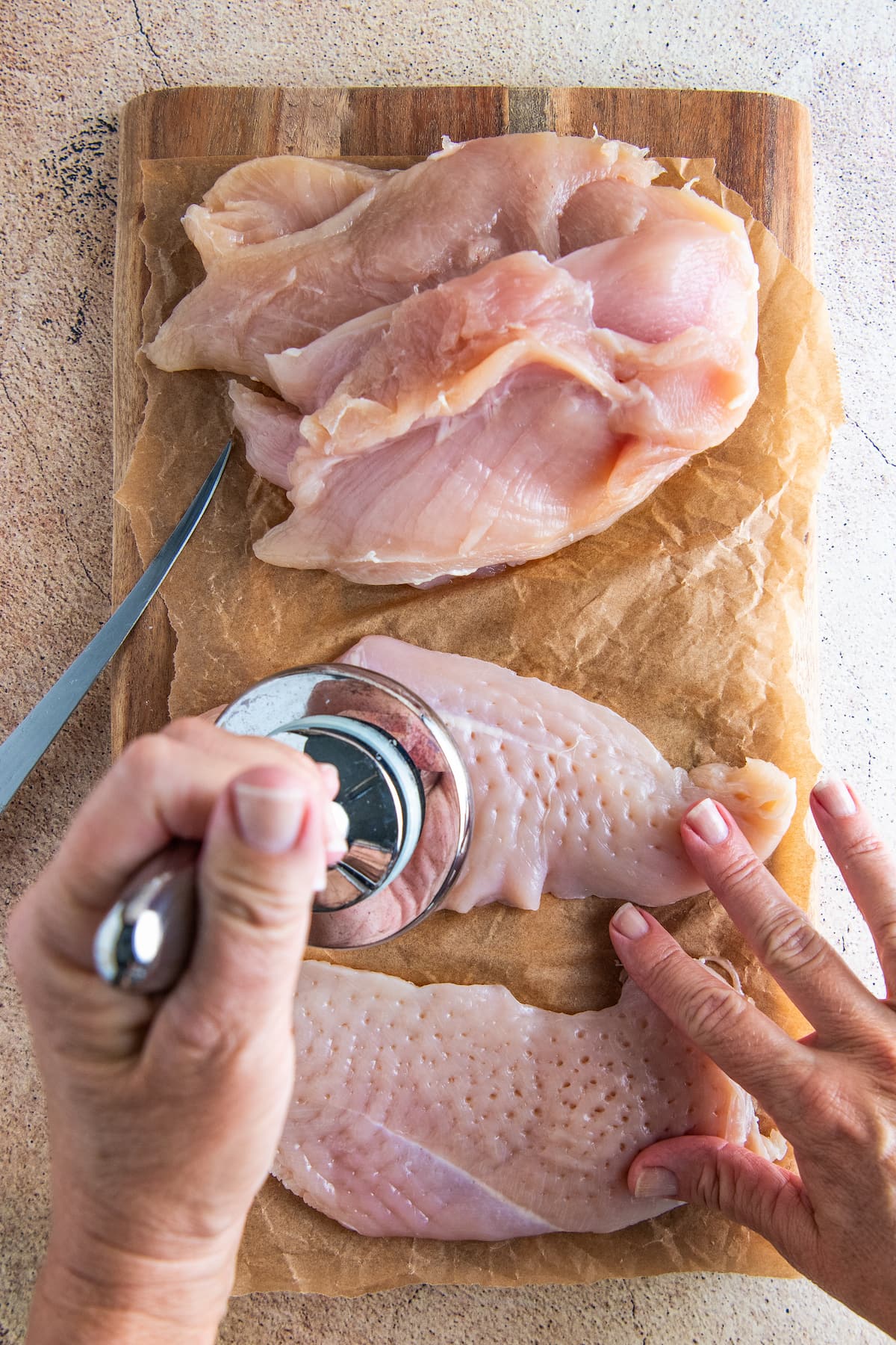 using a mallet to pound chicken breasts