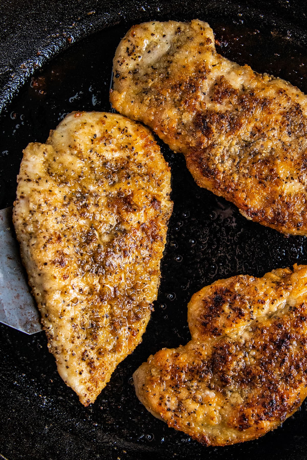 three pan fried chicken breasts
