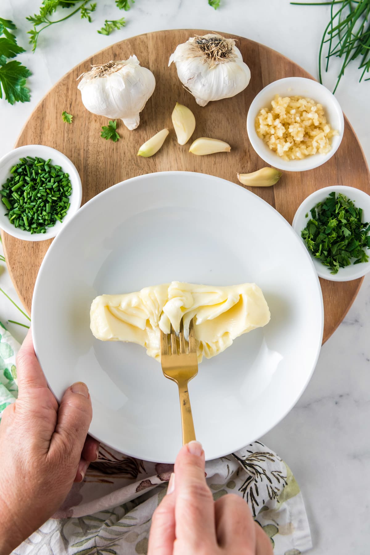 smashing butter in a white bowl with a fork