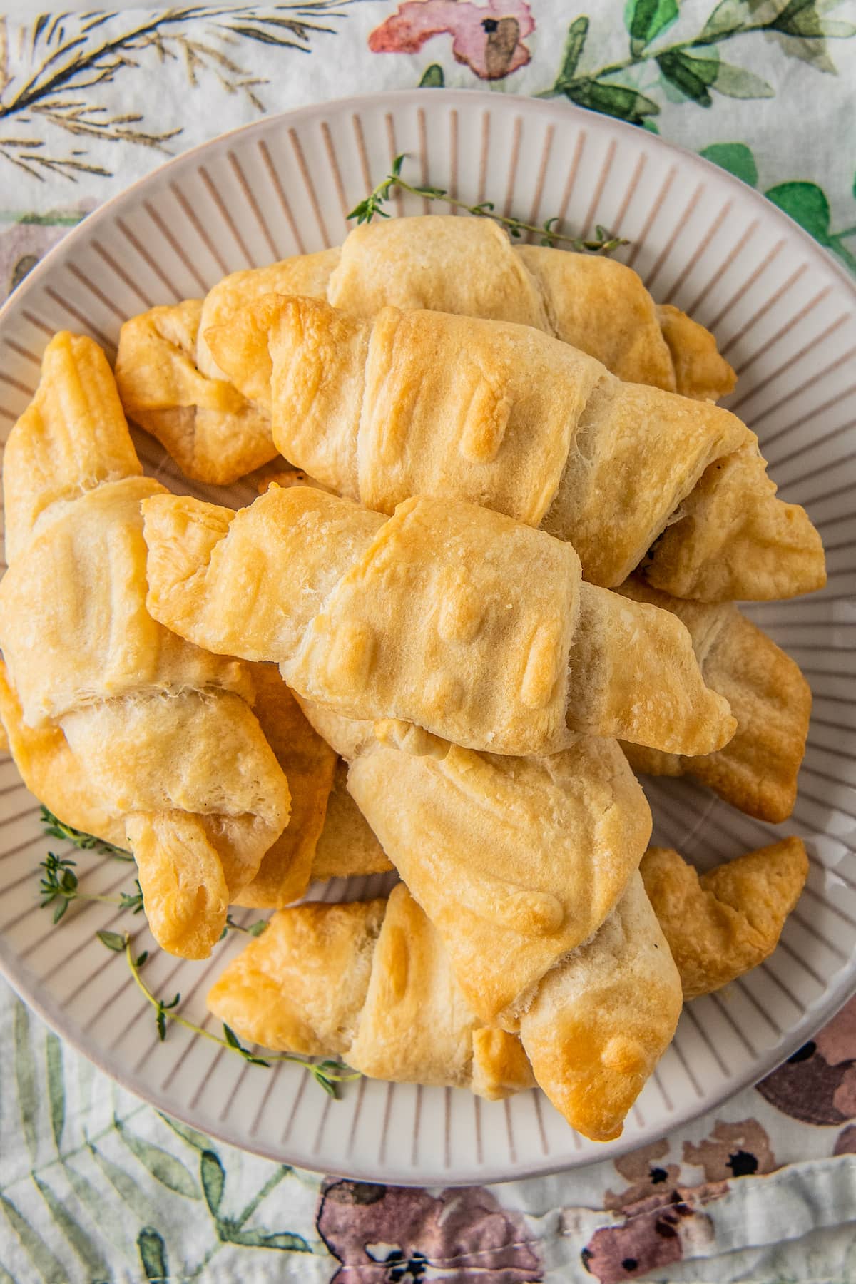 a large plate with a pile of baked crescent rolls