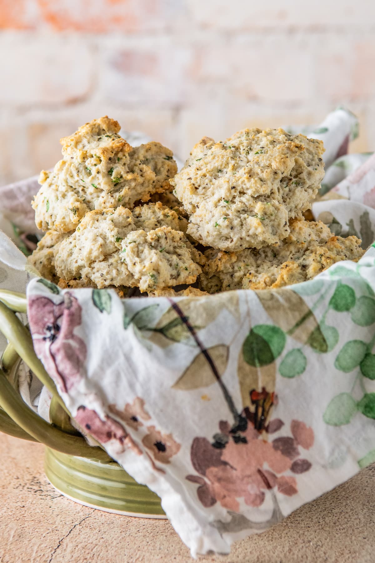 baked herb biscuits in a bowl with a tea towel