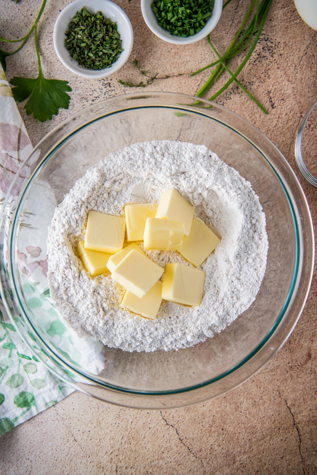 pads of butter in a flour mixture in a glass bowl