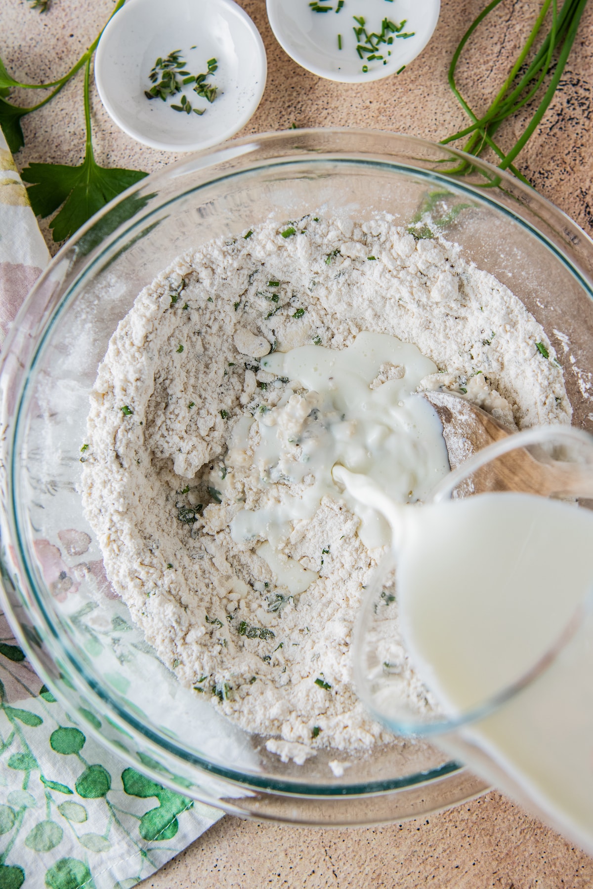 pouring cream into an herb and flour mixture