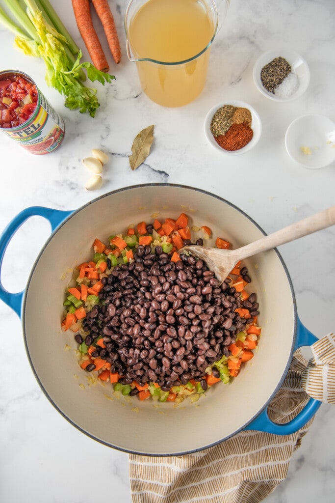 a large pot with black beans and diced vegetables