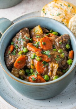 A bowl of beef stew with carrots and potatoes.