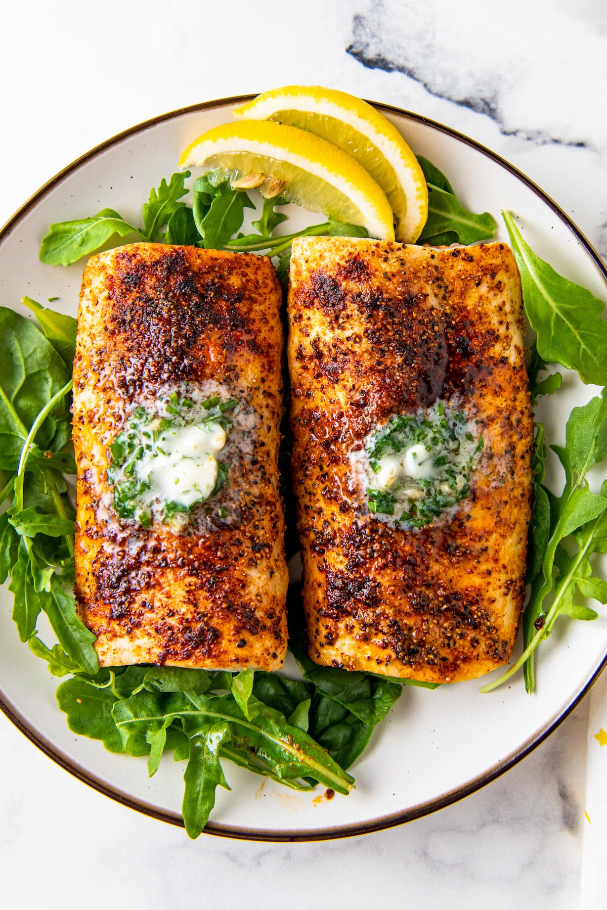 air fryer mahi mahi with seasoning and herb butter on a bed of lettuce