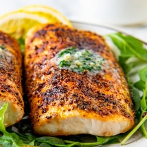 air fryer mahi mahi with seasoning and herb butter on a bed of lettuce