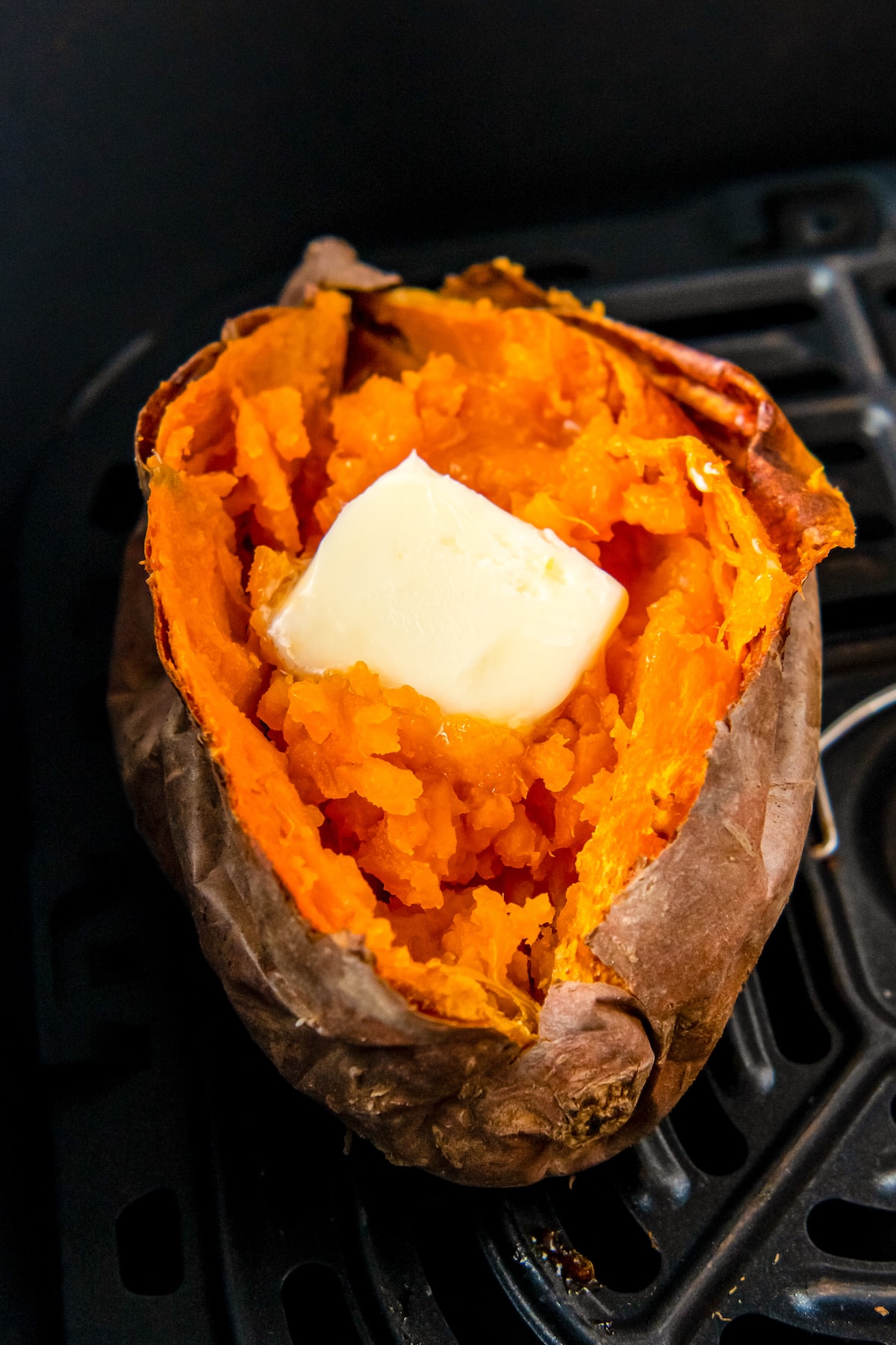 one cooked sweet potato with butter