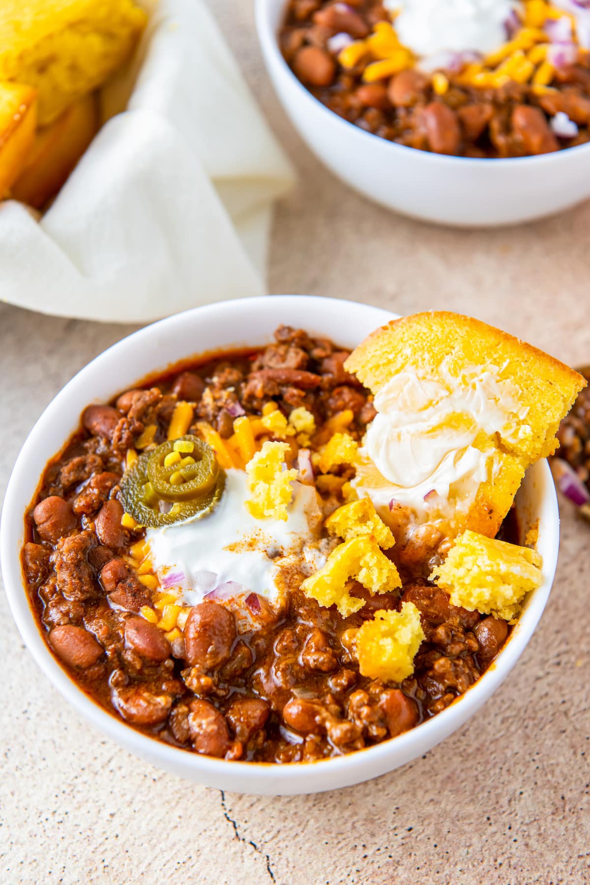 a big bowl of chili with a piece of cornbread in it