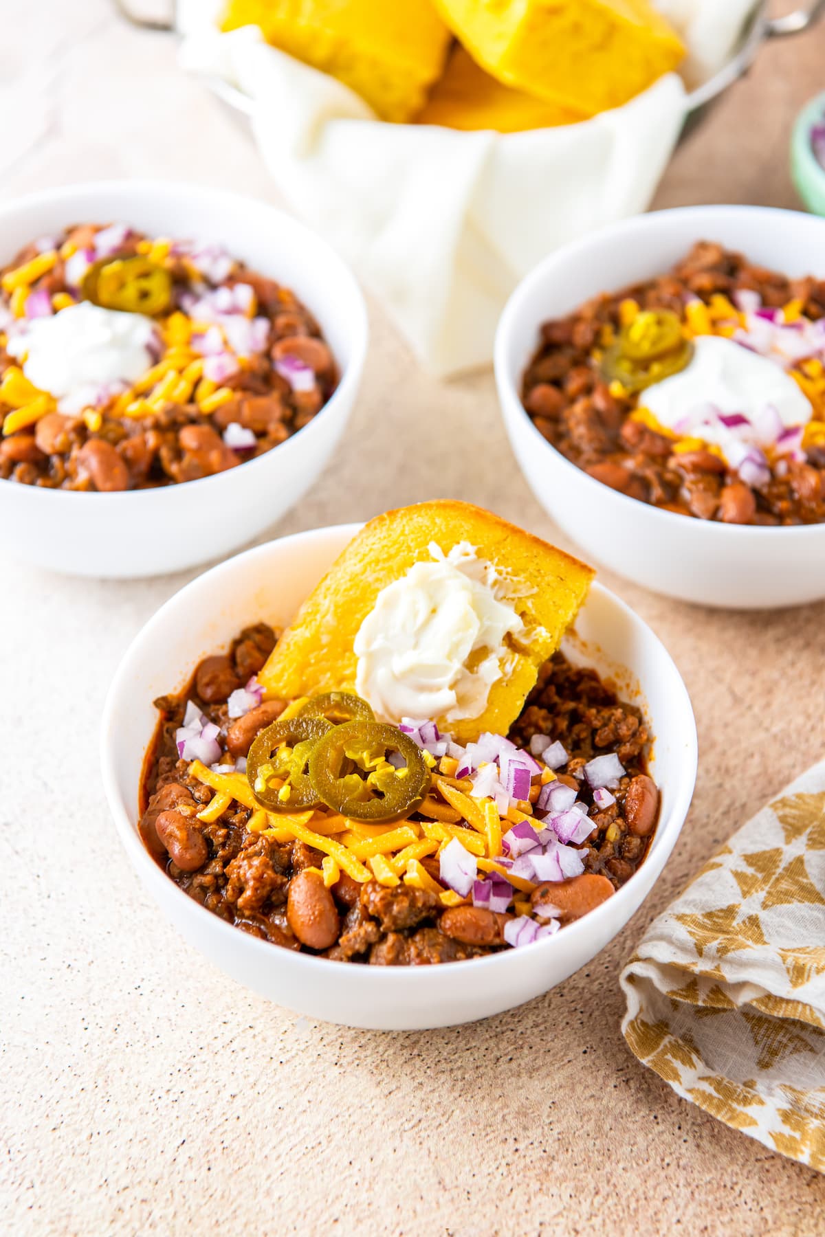 three bowls of easy chili with slices of cornbread