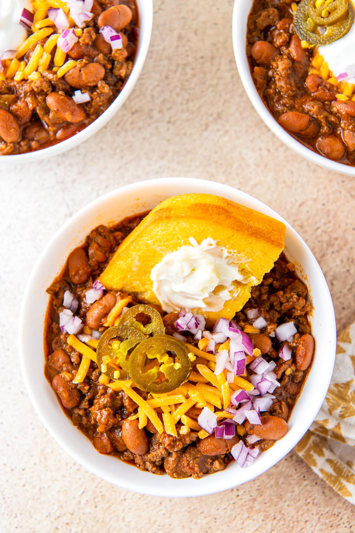 a big bowl of chili with a piece of cornbread in it