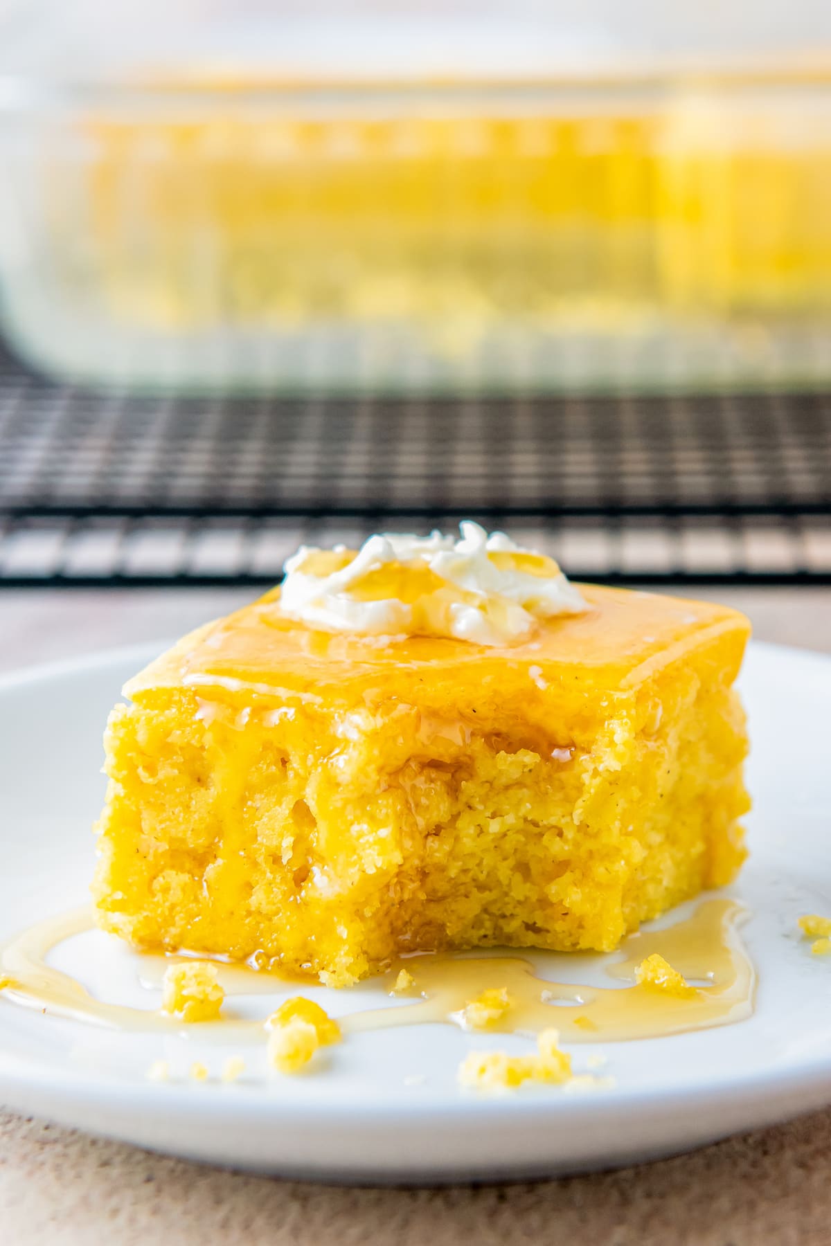 a piece of cornbread with a bite taken out of it on a plate with butter on top