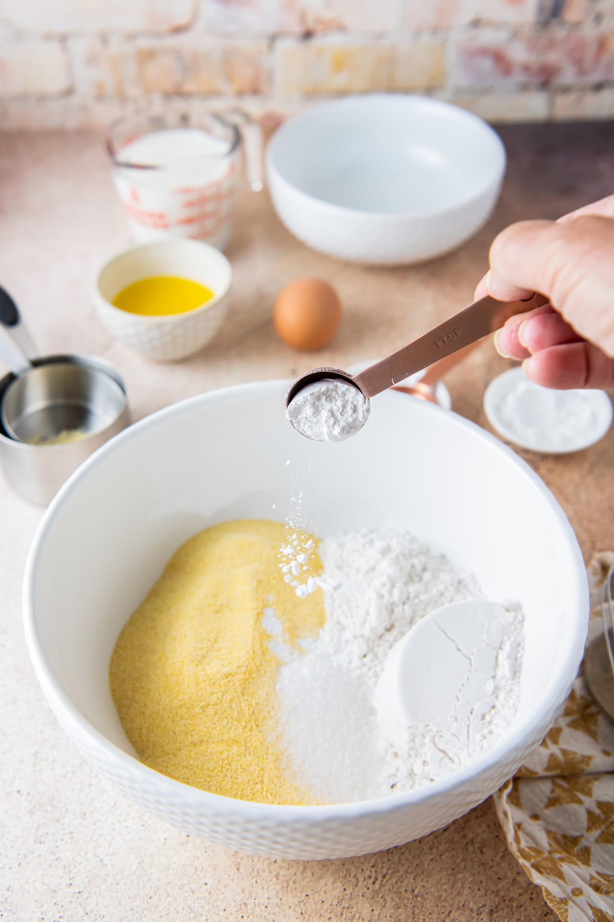 adding dry ingredients to a mixing bowl