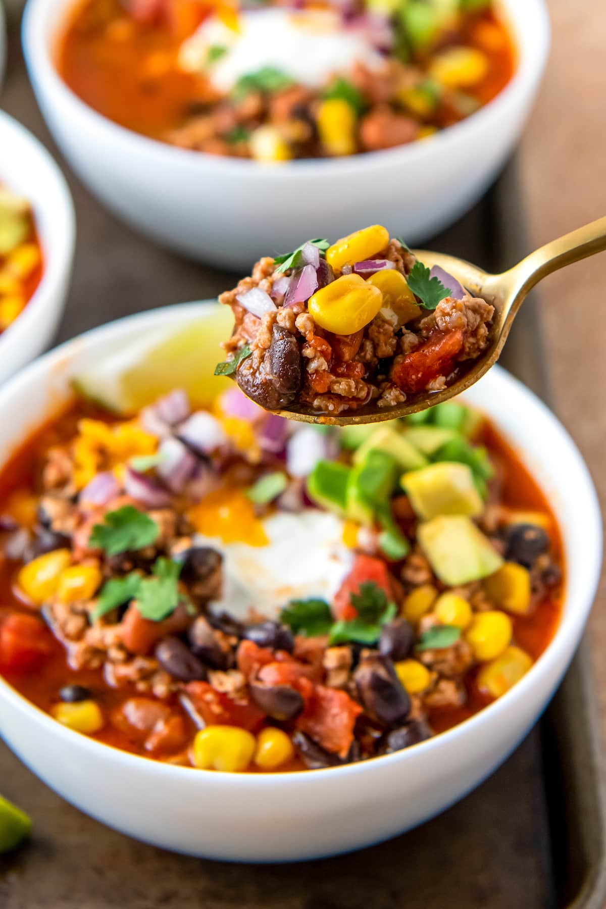 a bowl of easy taco soup with sour cream, avoacdo, and cilantro garnish