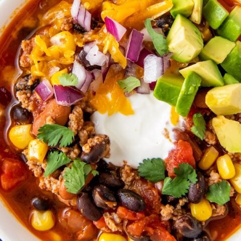 a bowl of easy taco soup with sour cream, avoacdo, and cilantro garnish