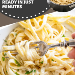 A fork picking up a bite of alfredo sauce on noodles.
