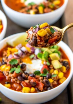 a bowl of easy taco soup with sour cream, avoacdo, and cilantro garnish