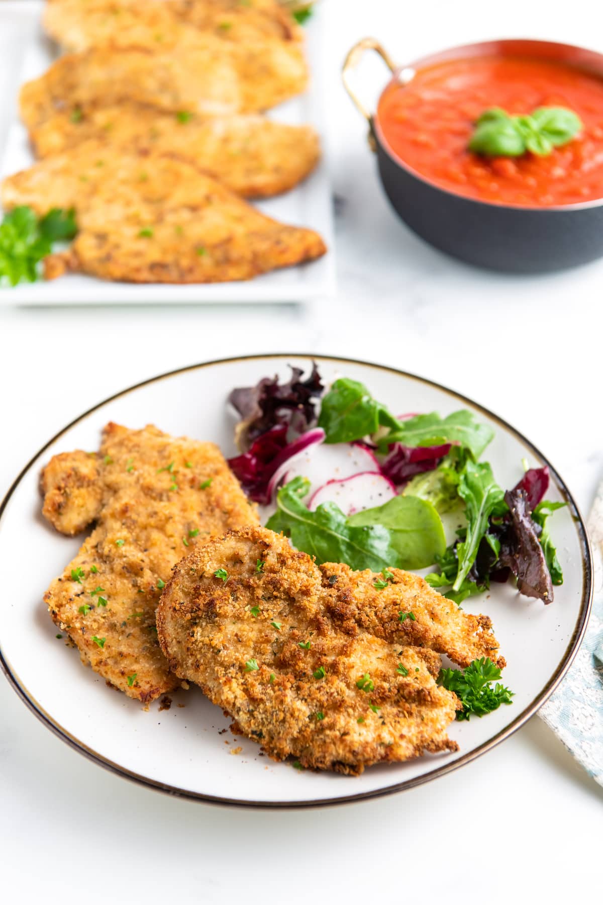 dinner plate with chicken cutlets and green salad