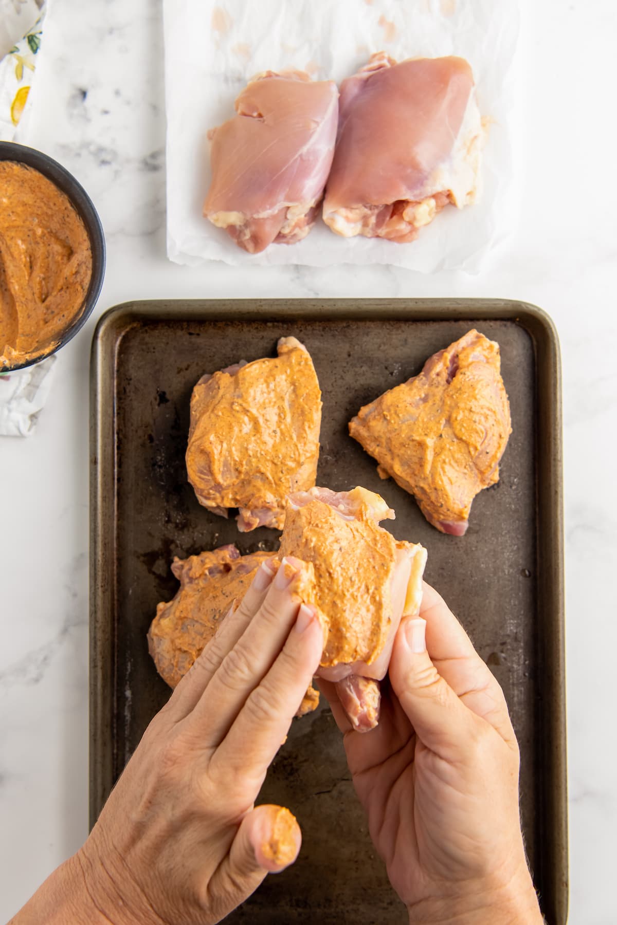 rubbing chicken thighs with seasoned mayonnaise