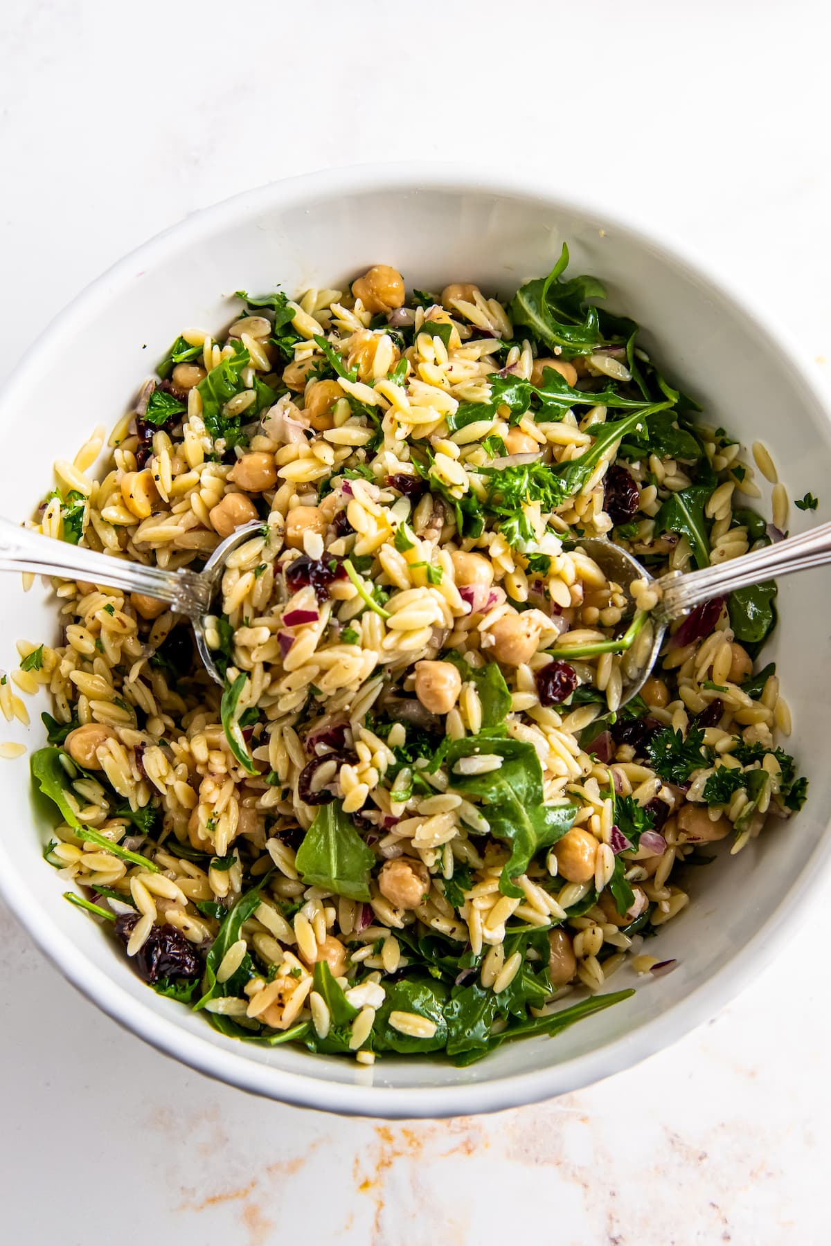 a bowl of salad made with orzo and arugula