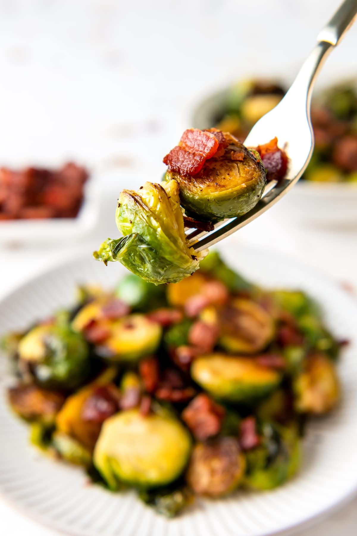 a fork with brussels sprouts and bits of bacon