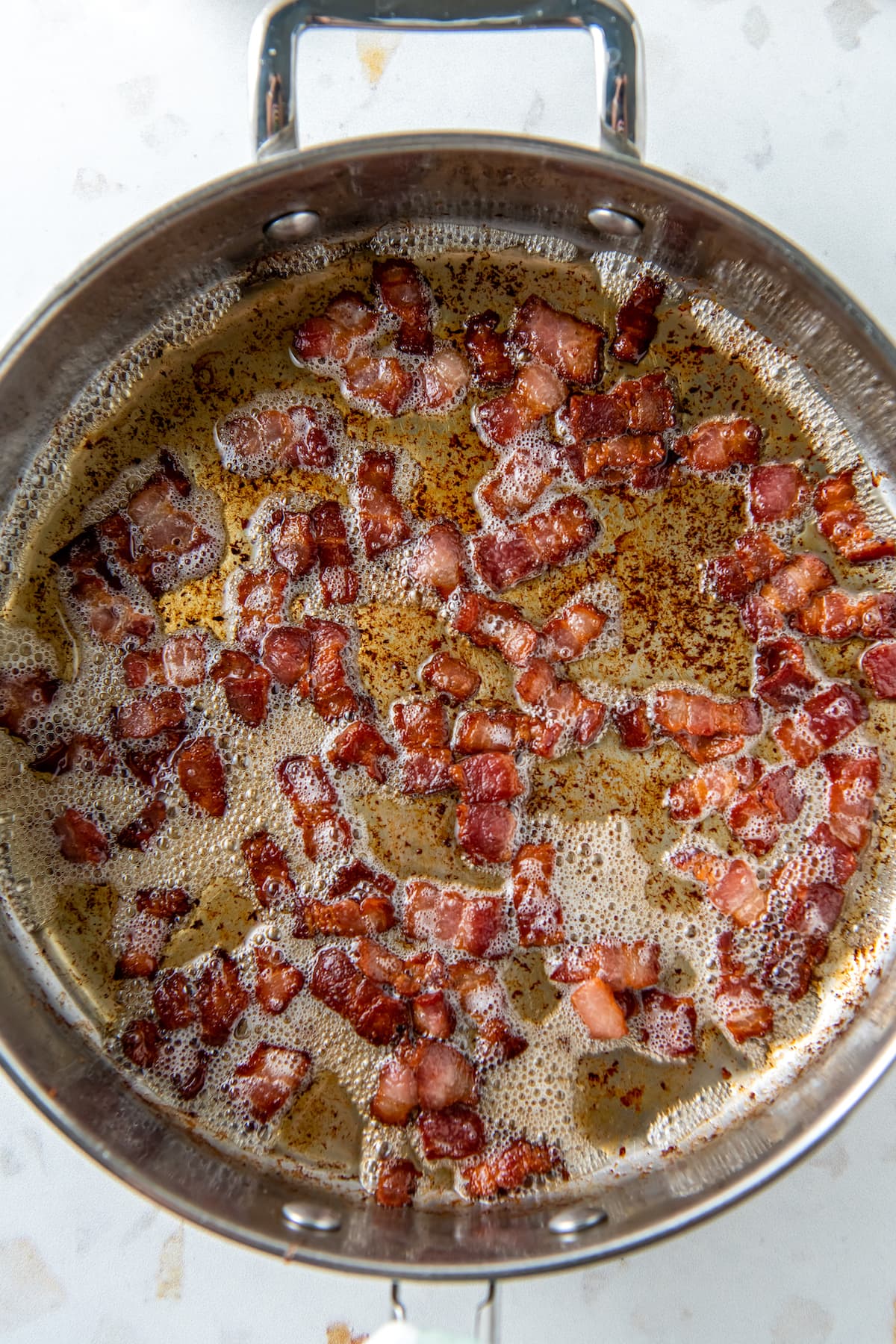 crisping bits of bacon in a pan