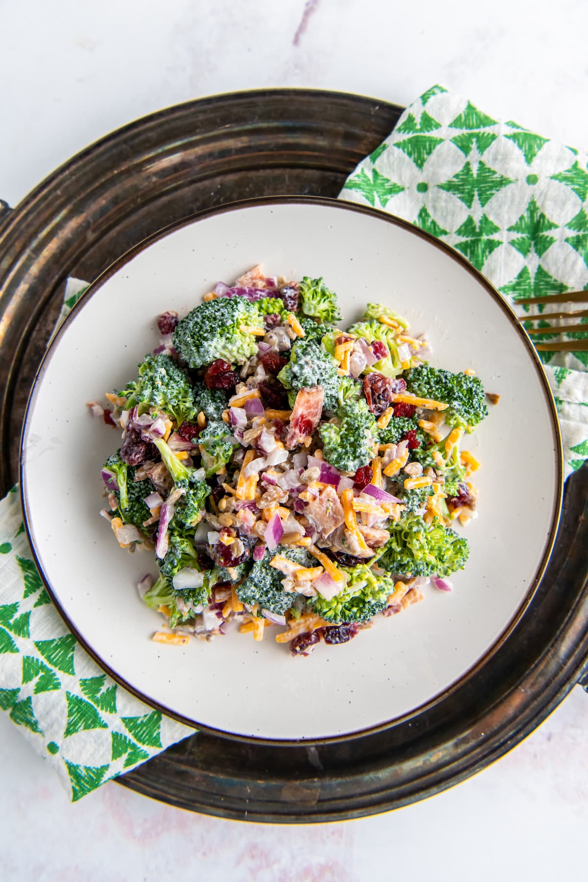 a plate with creamy broccoli salad with bacon and shredded cheese