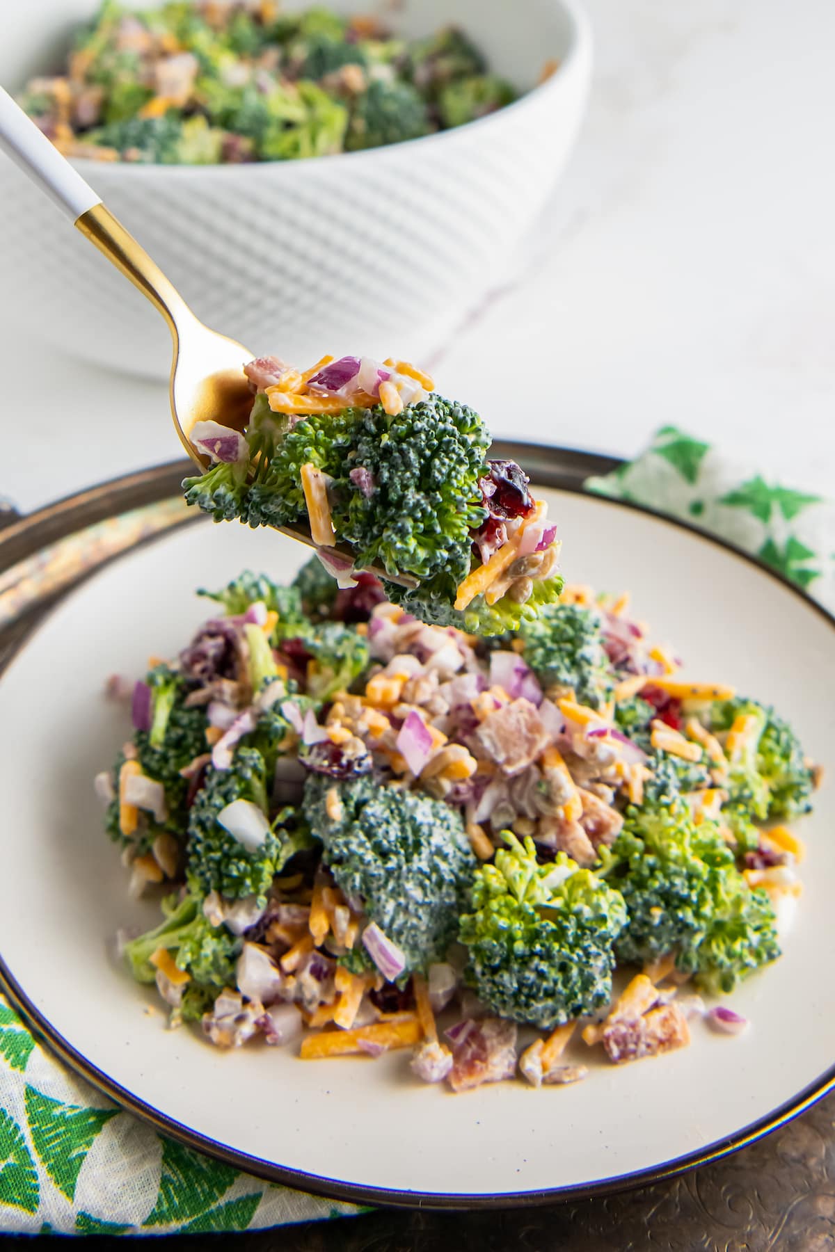 a plate with creamy broccoli salad with bacon and shredded cheese