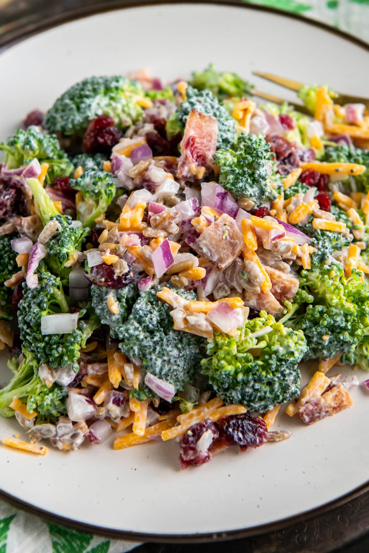 close up of broccoli and bacon salad with creamy dressing and shredded cheese