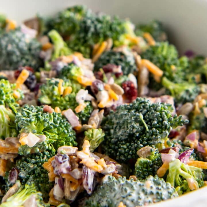 close up of broccoli and bacon salad with creamy dressing and shredded cheese