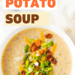 A bowl of potato soup with bacon, chives and green onions on top.