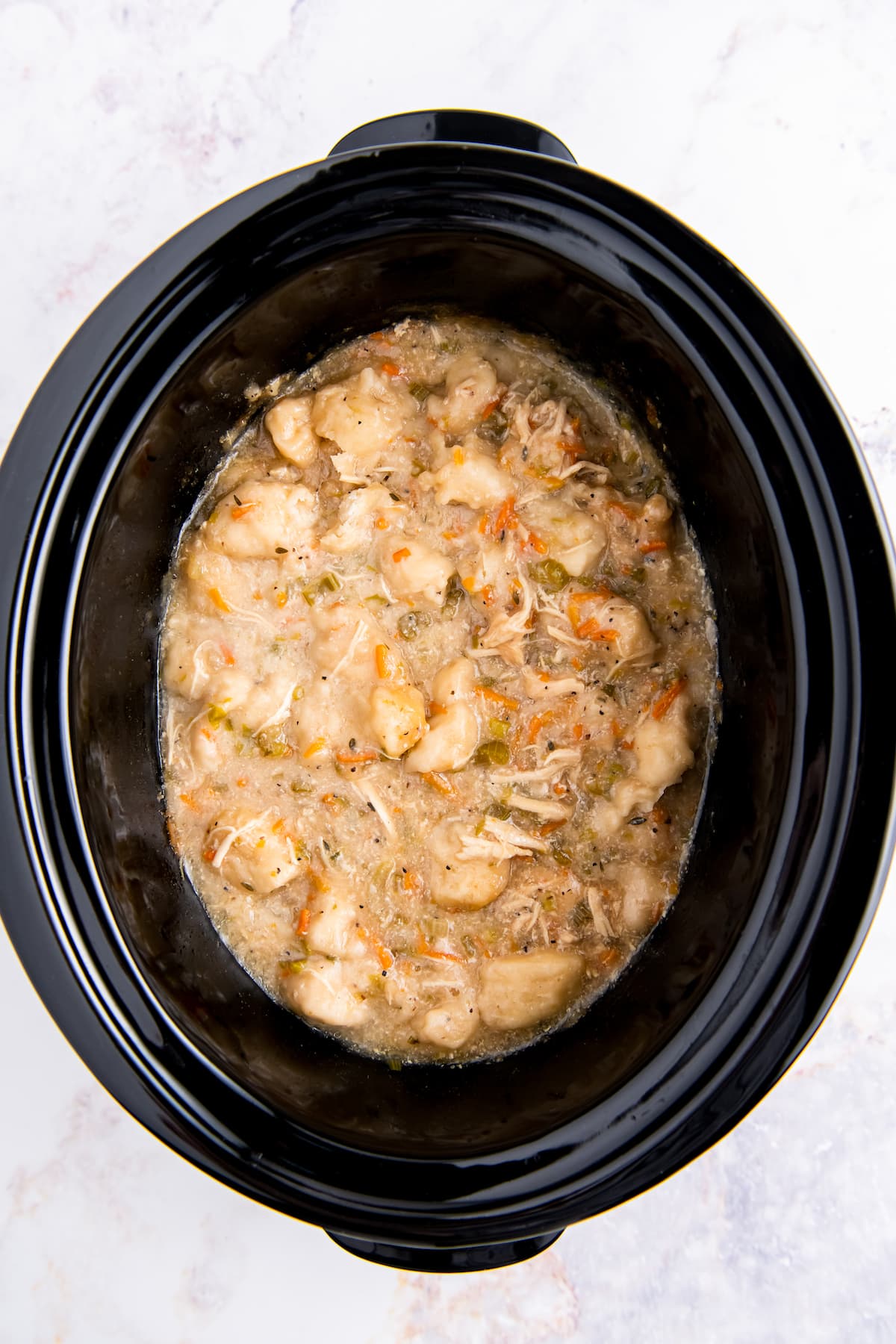 chicken and dumplings being cooked in a crockpot