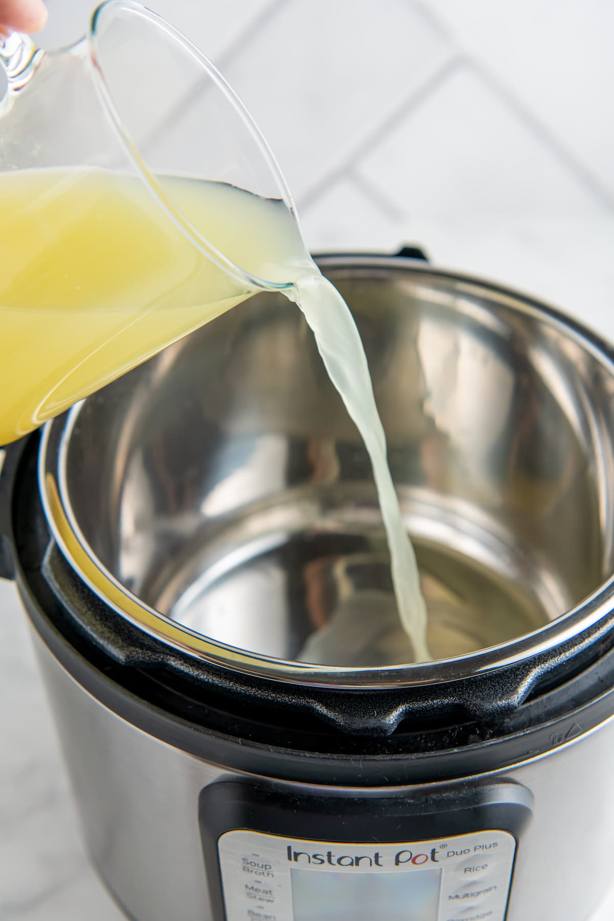 pouring broth into an instant pot