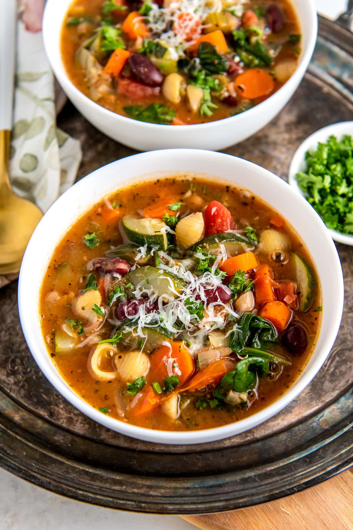 a bowl of minestrone soup with a rich tomato broth, vegetables, noodles, and cheese