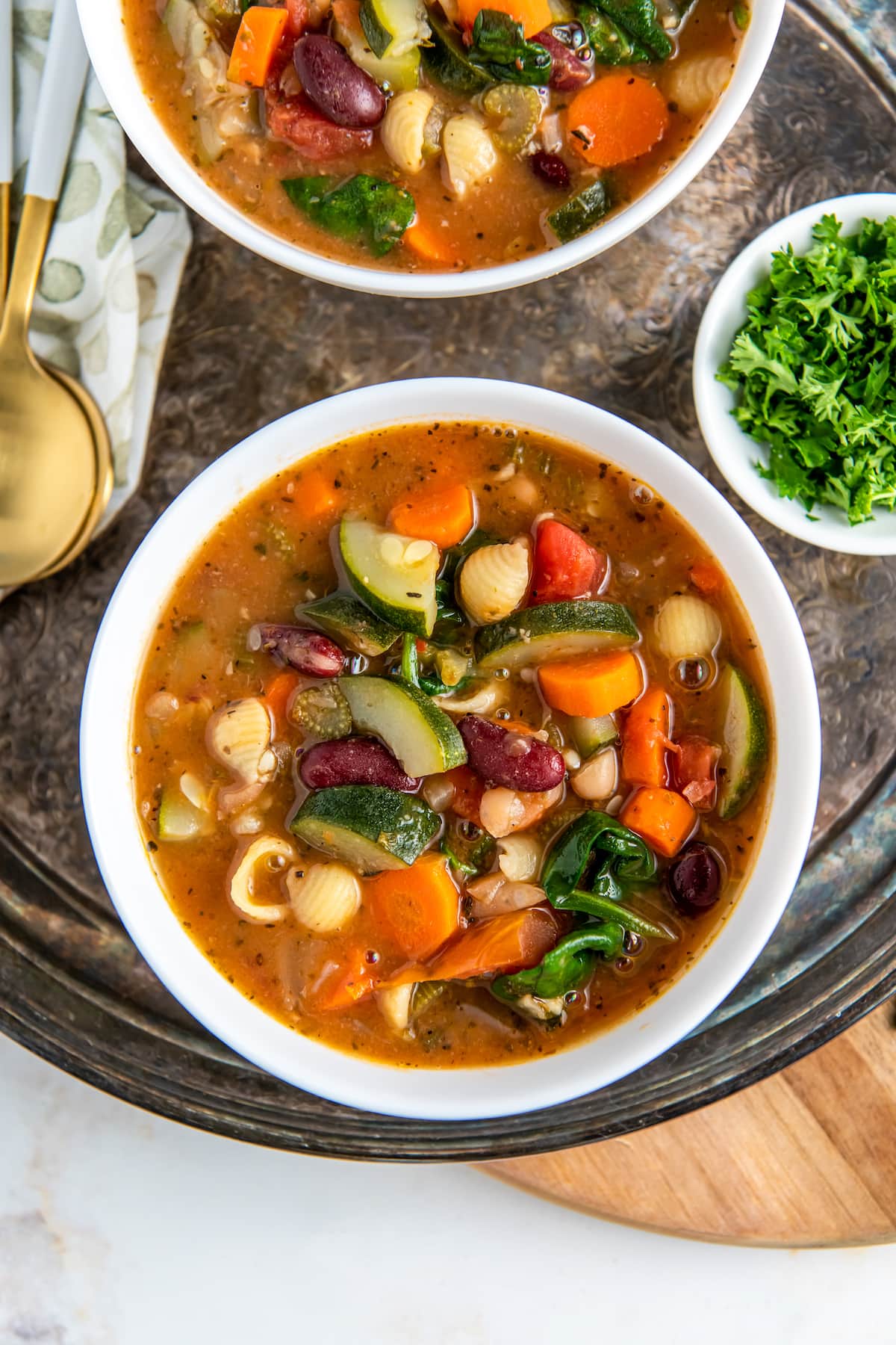 a bowl of minestrone soup with a rich tomato broth, vegetables and noodles