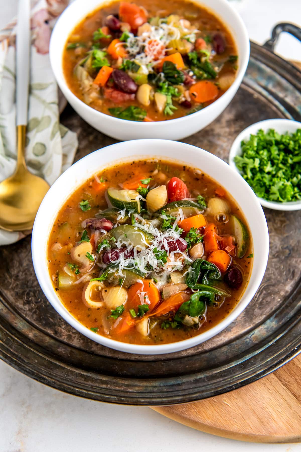 a bowl of minestrone soup with a rich tomato broth, vegetables, noodles, and cheese