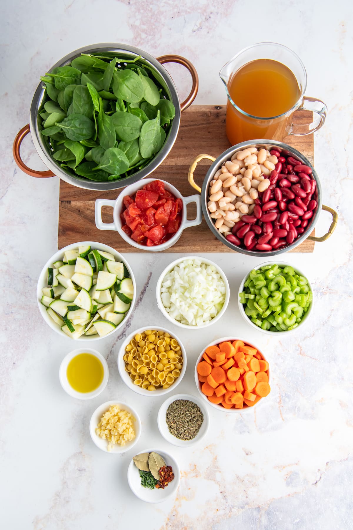 the prep to make a vegetable soup with the ingredients in small bowls and measureed out on a countertop