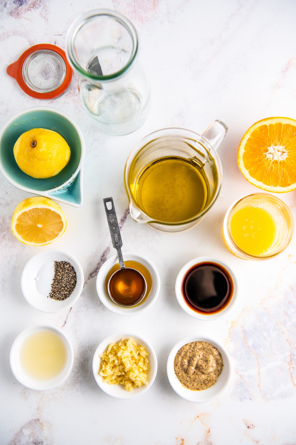 ingredients to make orange salad dressing on a counter in small bowls