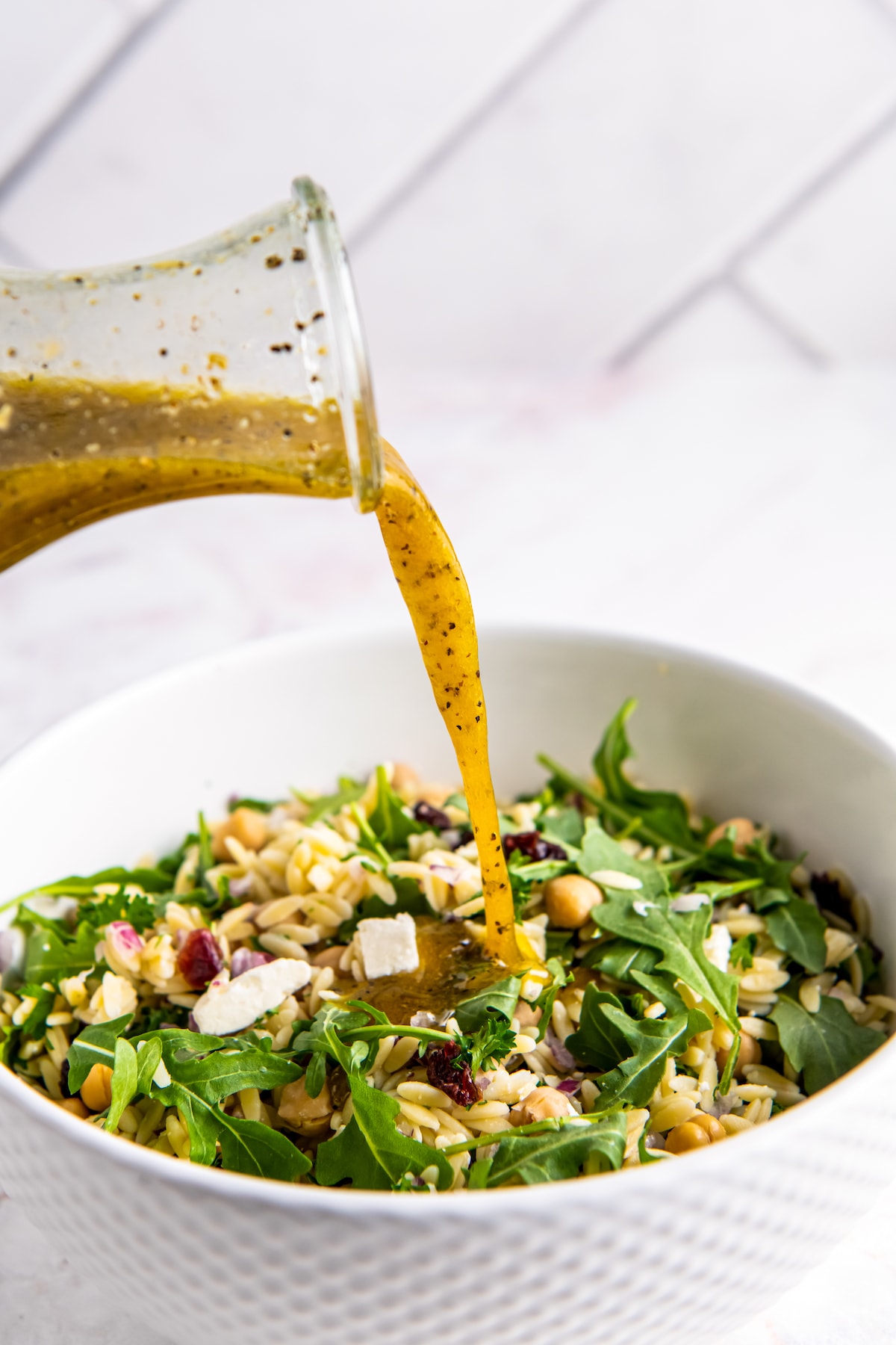 pouring dressing over a salad