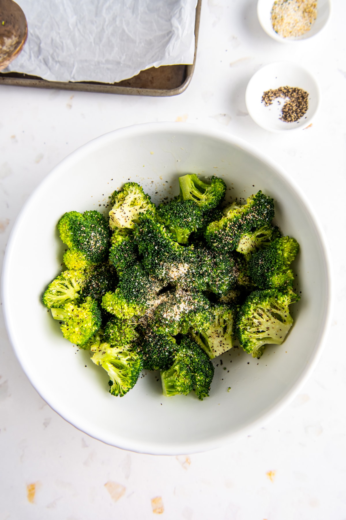 a bowl of broccoli and seasonings