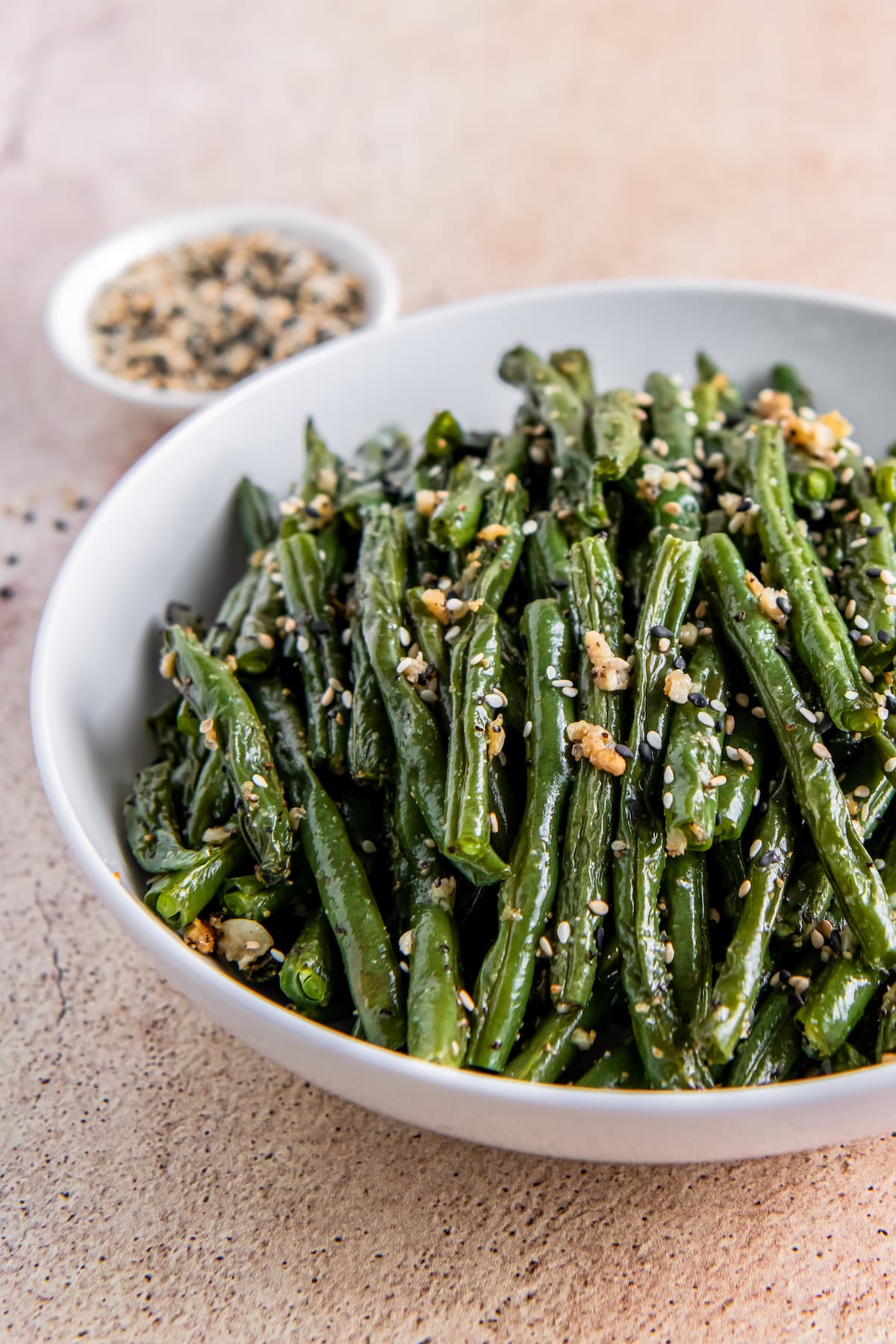 a bowl of roasted green beans with minced garlic mixed in