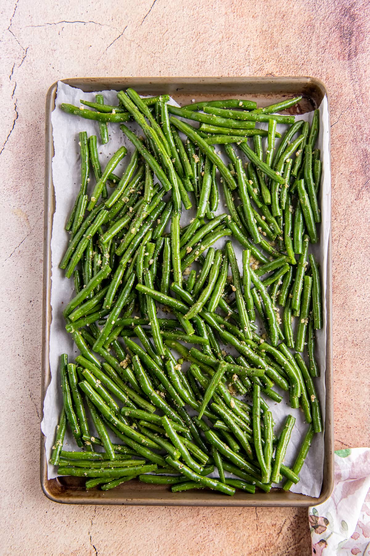 green beans that have been seasoned laying on a sheet tray