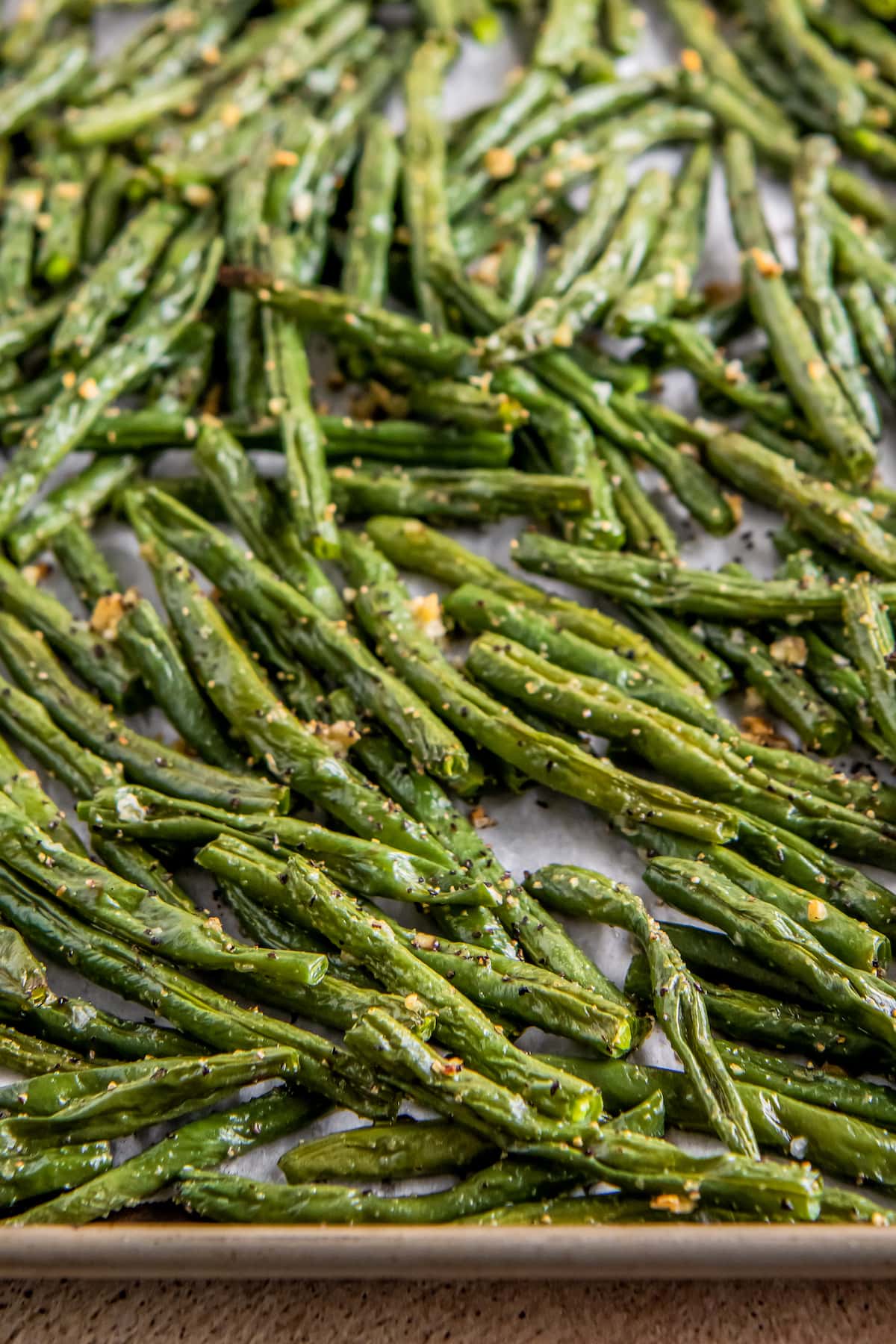 cooked green beans laying on a sheet tray