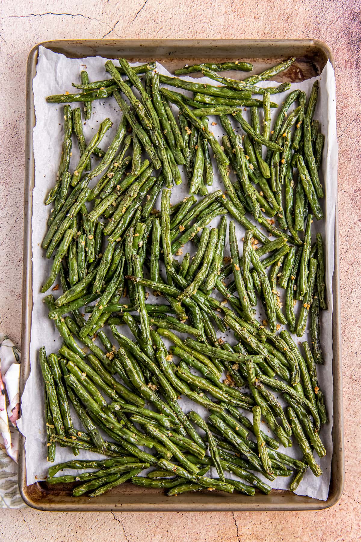 cooked green beans laying on a sheet tray