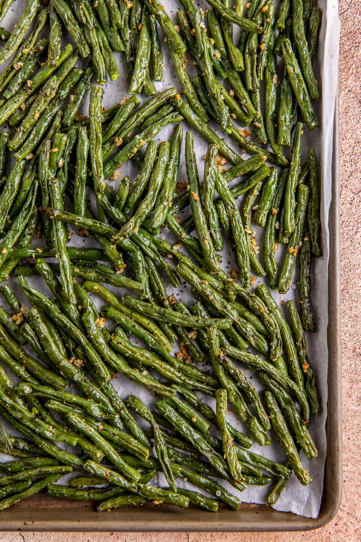 cooked green beans laying on a sheet tray