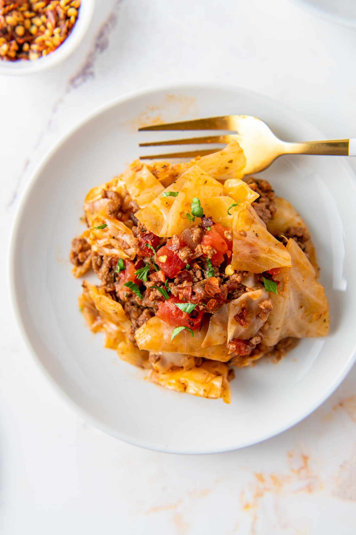 a plate of unstuffed cabbage rolls made with cabbage, beef, and tomatoes