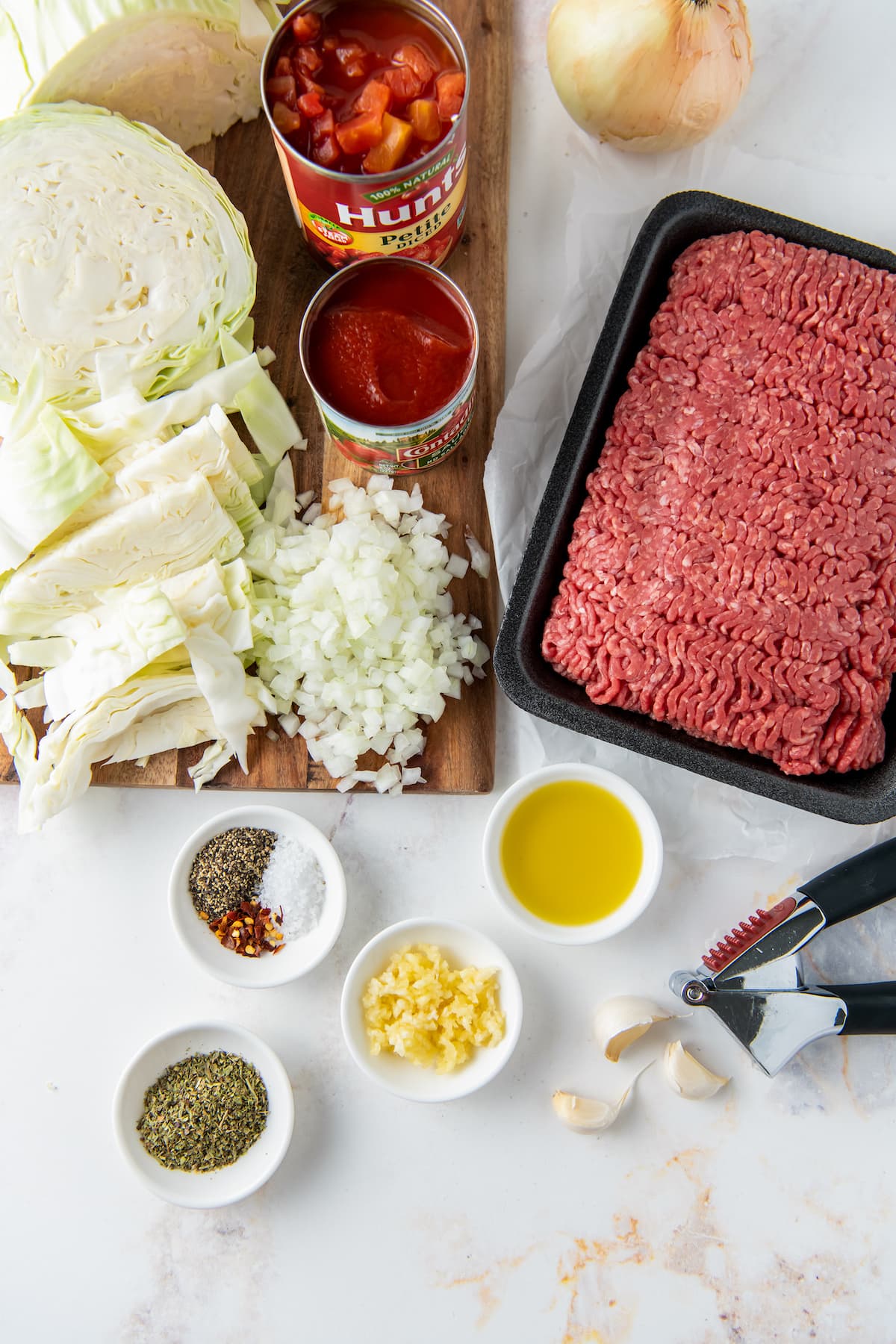 ingredients to make unstuffed cabbage dinner with ground beef, cabbage, onion, garlic, oil, and seasonings