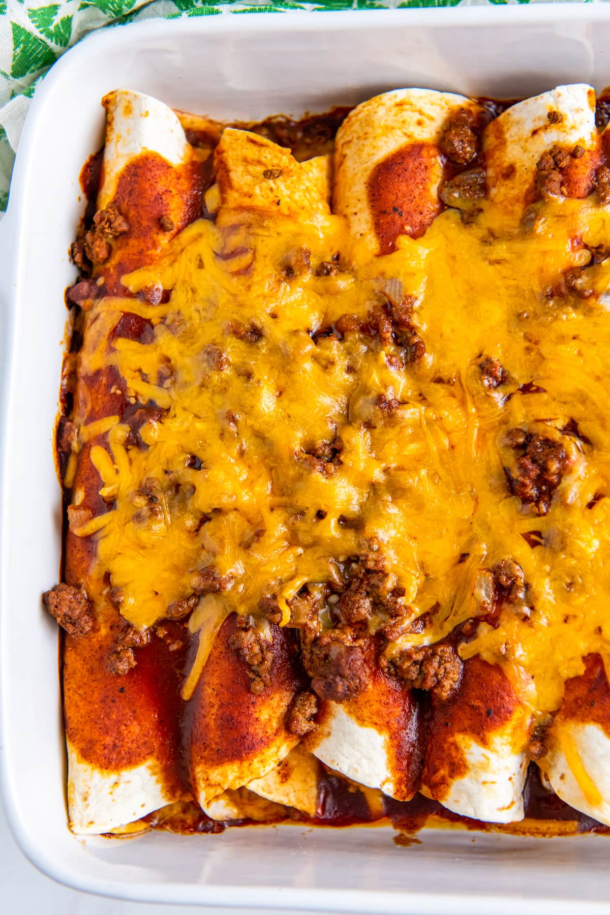 beef enchiladas that are topped with melted cheese and red sauce