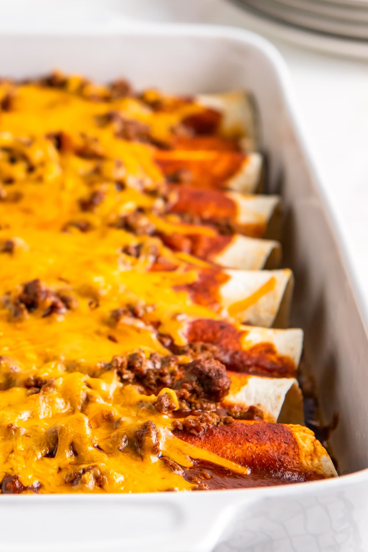 beef enchiladas that are topped with melted cheese and red sauce